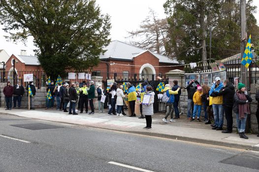 Protest outside the Russian Embassy on Orwell Road, people holding blue and yellow flags in solidarity with Ukraine
