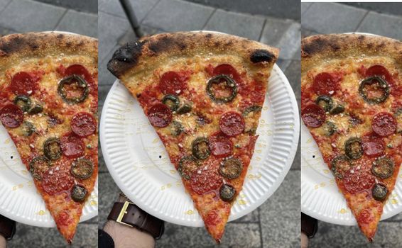 NY-style pizza on a paper plate with pepperoni and jalapenos