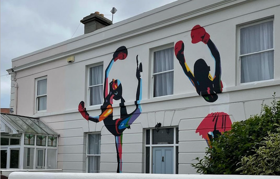 mural of two ballerinas on the front of a period home