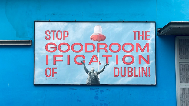 billboard with pale blue background and illustrations of lampshade and Jim Larkin reads "stop the goodroomification of Dublin!"