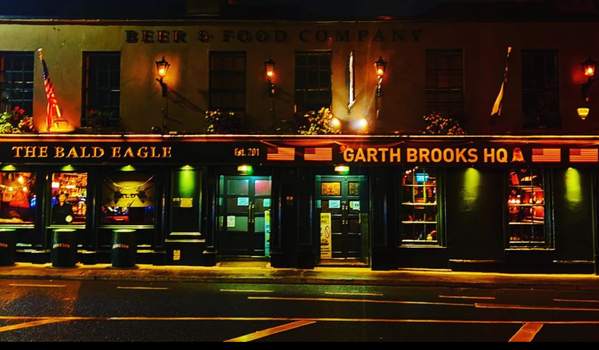 exterior of a pub at nighttime with a sign that reads "garth brooks hq"