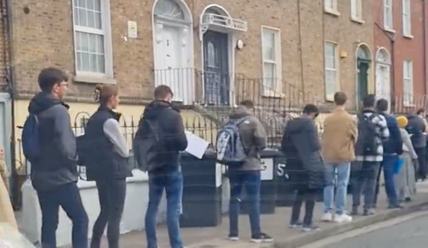 several people standing in a queue on cabra road, dublin